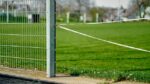 white metal fence on green grass field during daytime